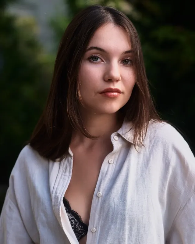 Portrait of Aida in white shirt against green backdrop, portrait session Wroclaw