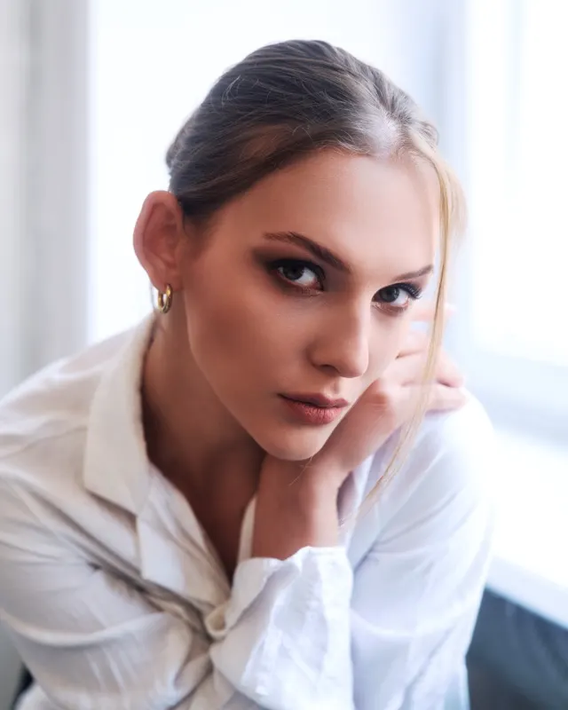 Portrait of Ania in white shirt resting face on hand, portrait session Wroclaw