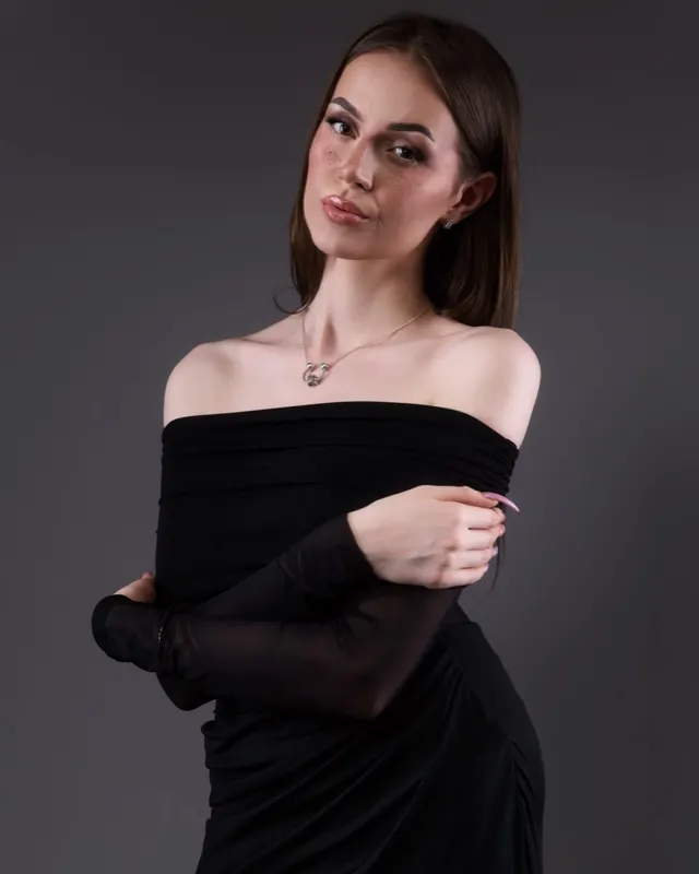 Daria in black off-shoulder dress on grey background, studio portrait session Wrocław