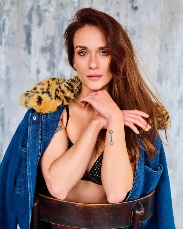 Portrait of Natalia in denim jacket with fur collar by wooden chair, portrait session Krakow