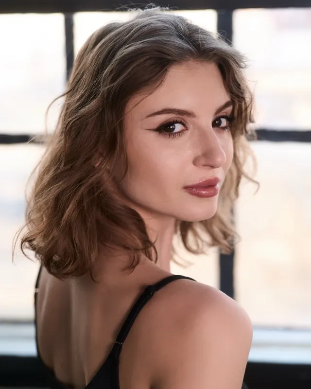 Portrait of Natalia with wavy hair by an industrial window, portrait session Wrocław