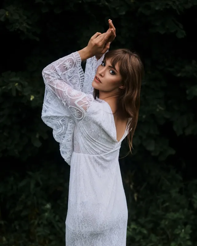 Wiktoria in white lace dress outdoors against greenery, portrait session Rzeszów