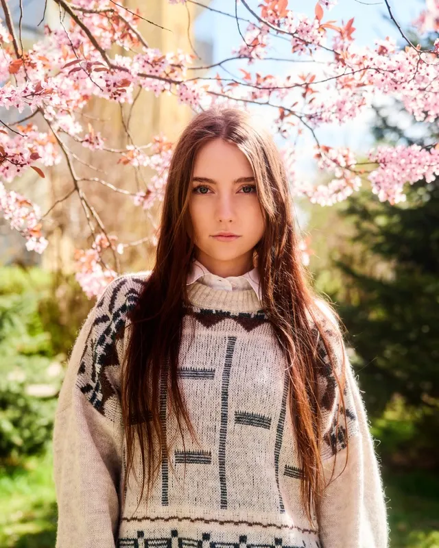 Wiktoria in oversized sweater against blooming cherry blossoms in spring, portrait session Wrocław