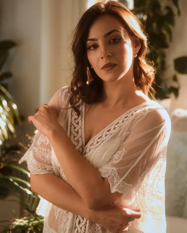 Magda in white lace robe in warm light among plants, women's photoshoot Wroclaw